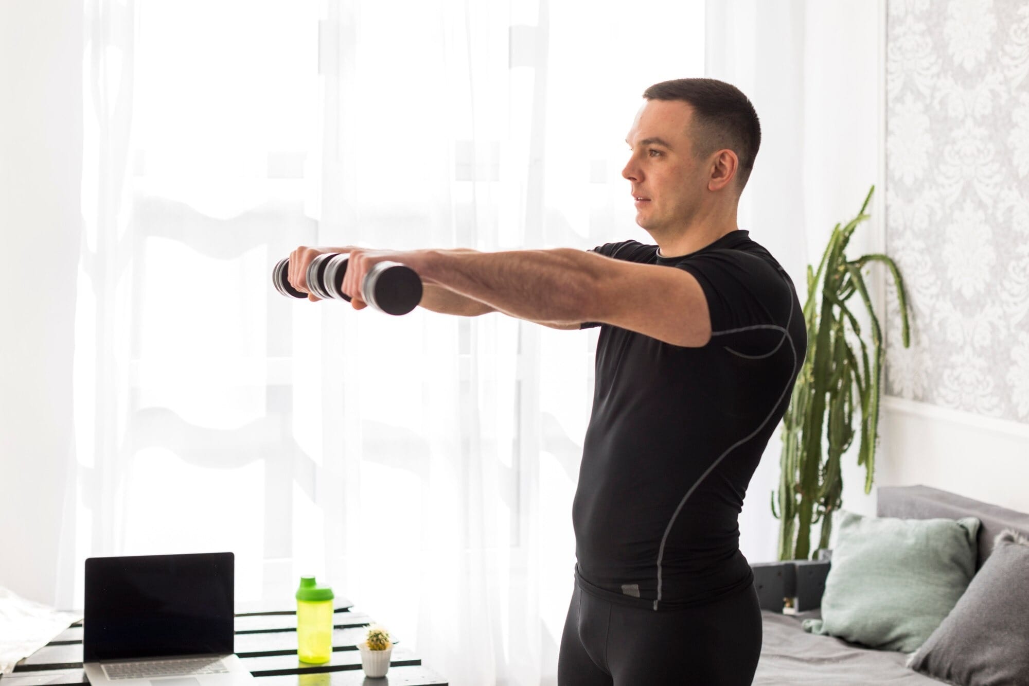 Homem executando exercícios para postura com halteres em casa, demonstrando alinhamento correto de ombros e coluna